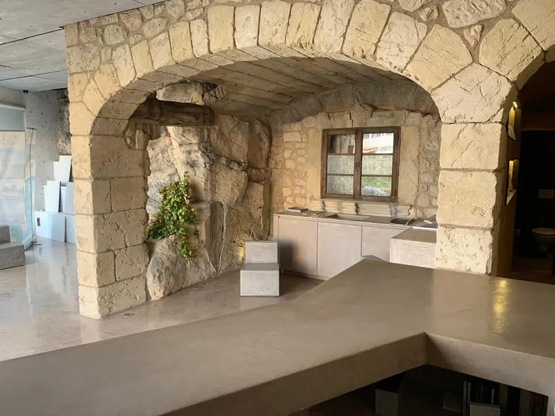 Arco de sillería con roca artificial y ventana tradicional en el showroom de 3Pols