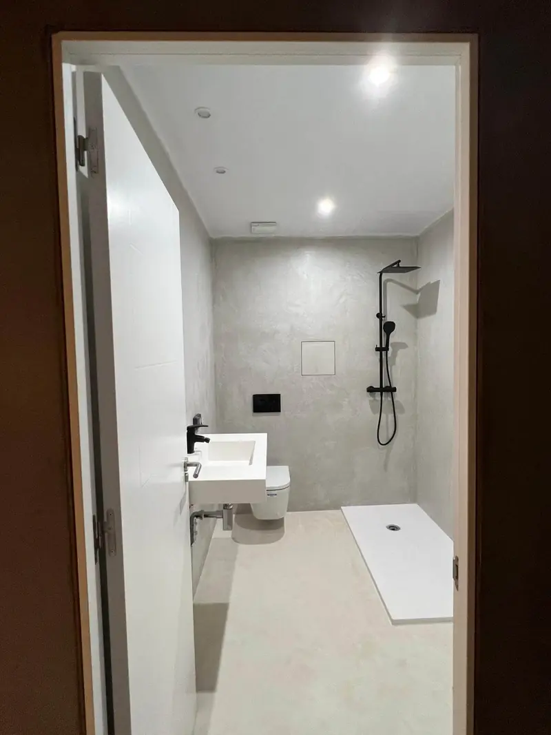 Baño con paredes y suelo de microcemento y zona de ducha