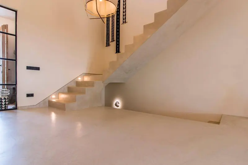 Escalera de microcemento con luces empotradas en la pared y suelo continuo