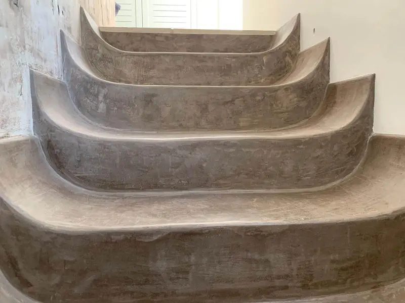 Escalera de peldaños curvos esculpidos en microcemento