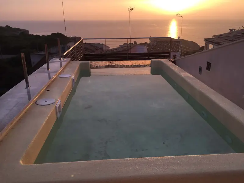 Piscina en una azotea al atardecer durante el llenado