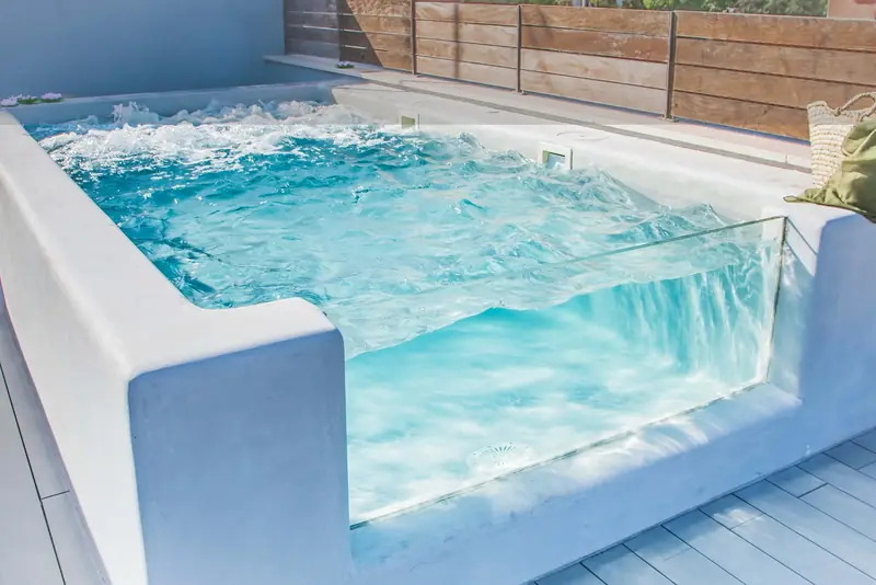 Piscina con lateral de cristal y borde de microcemento