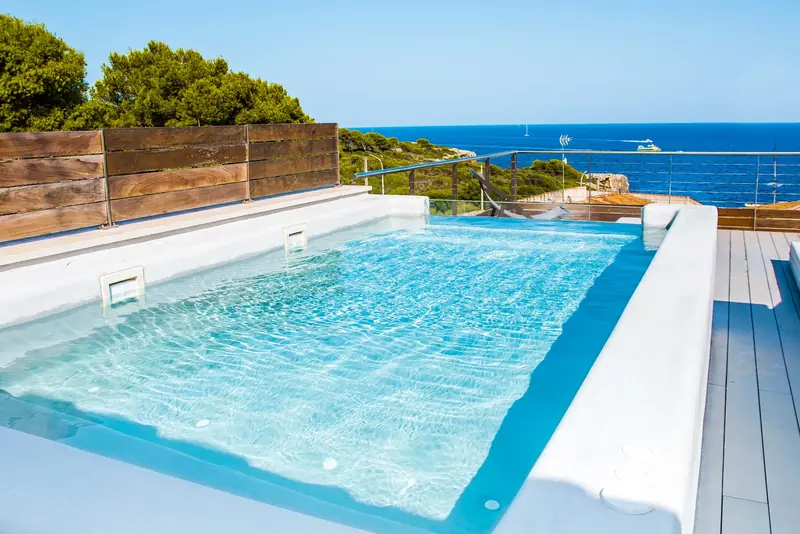Piscina ligera en una terraza con vistas al mar y borde blanco de microcemento