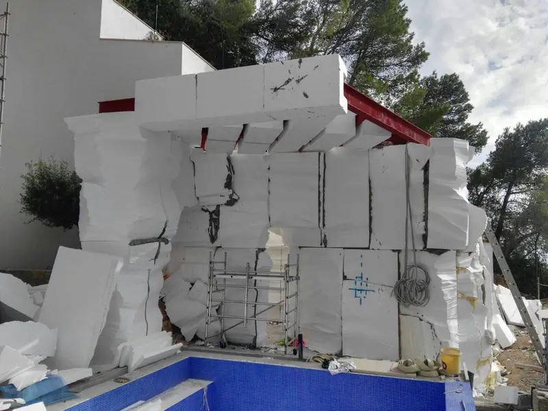 Estructura de bloques de poliestireno para una roca artificial sobre una piscina en obra