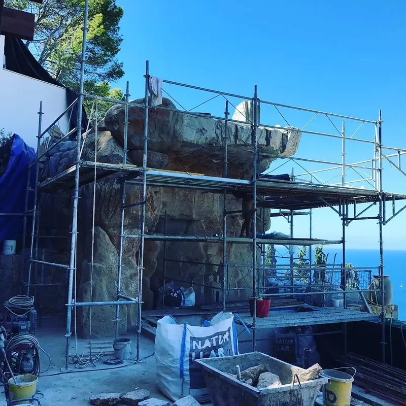 Formación de roca artificial en construcción, con andamio, junto al mar