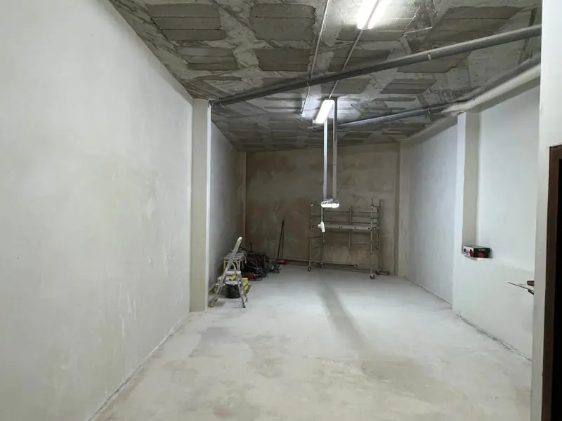 Antes: el local durante la obra, con paredes preparadas y suelo de hormigón