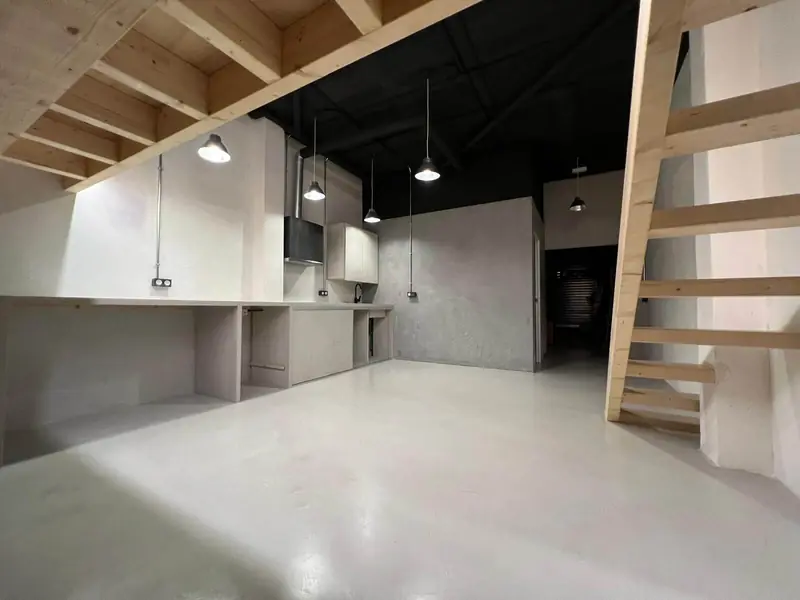 Después: loft de planta abierta con suelo continuo de microcemento