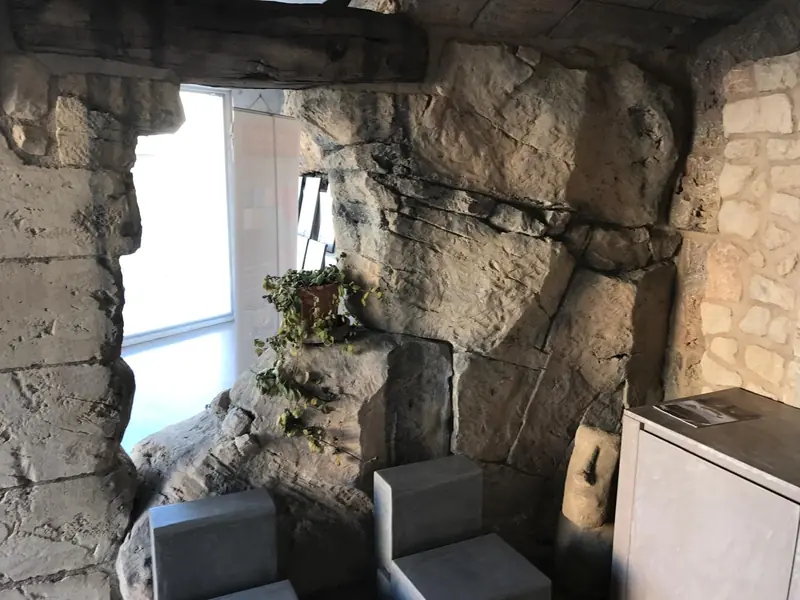 Ventana enmarcada por roca artificial y piedra en un interior